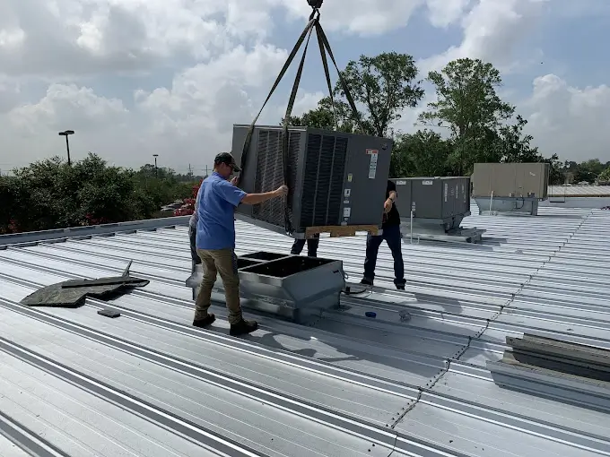 A picture of a Duggan's AC & Heating Technicians installing an outdoor unit for the question "Is Ruud a Good Air Conditioner for All Seasons?"